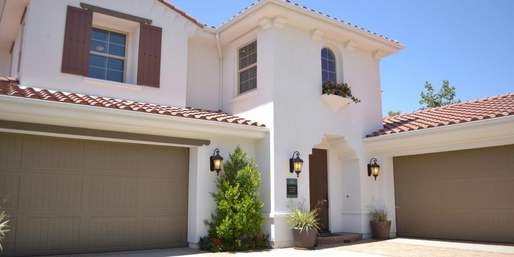 Bright suburban home with classic architecture and landscaped garden, ideal for real estate listings.
