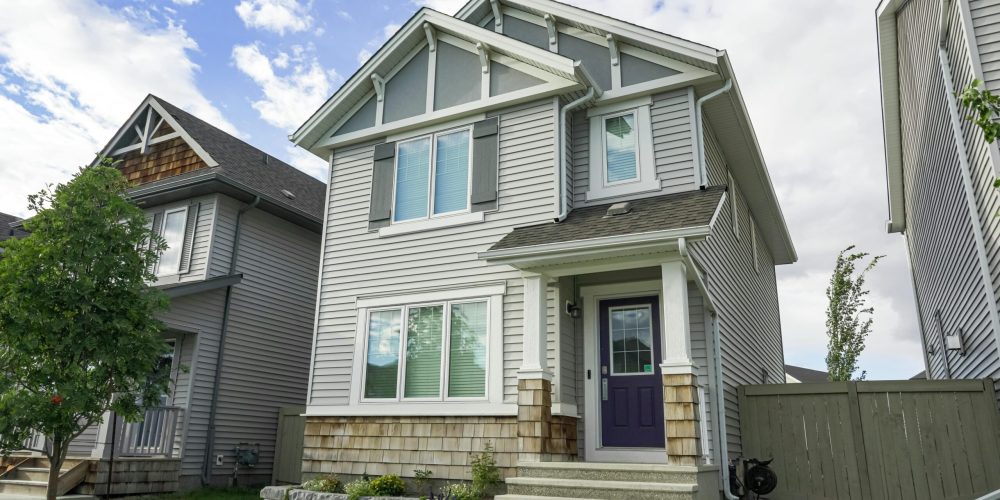 Contemporary suburban home with a front porch and clear blue sky, ideal for real estate themes.